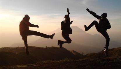 Jugendliche springen vor Freude in den Bergen in die Luft