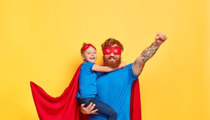 Vater mit Tochter im Superheldenkostüm